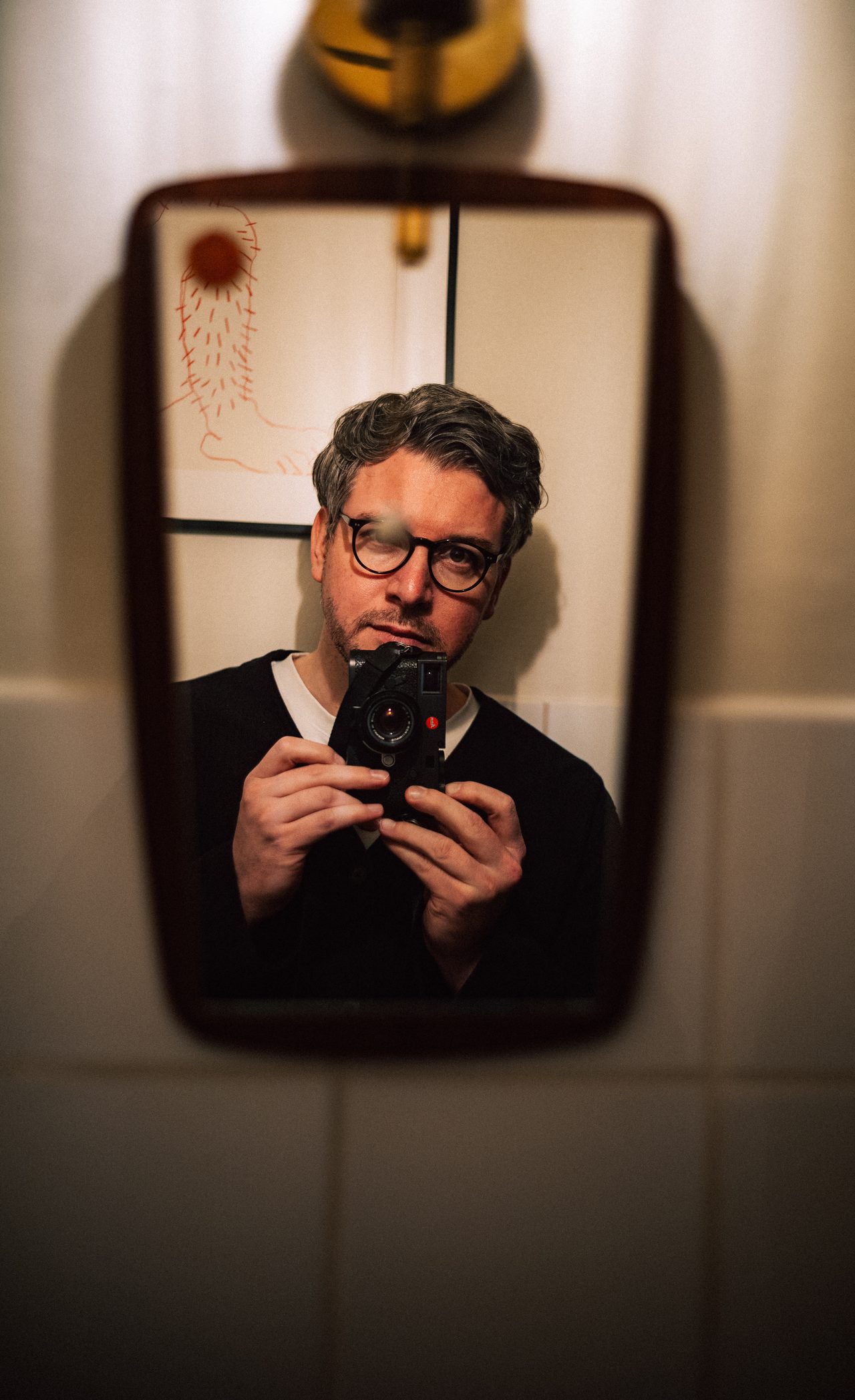 Thomas Pullert holding a camera in a mirror