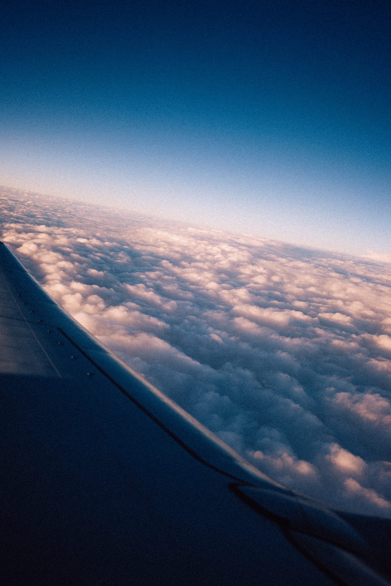 Blick aus einem Flugzeug auf Wolken und Tragfläche